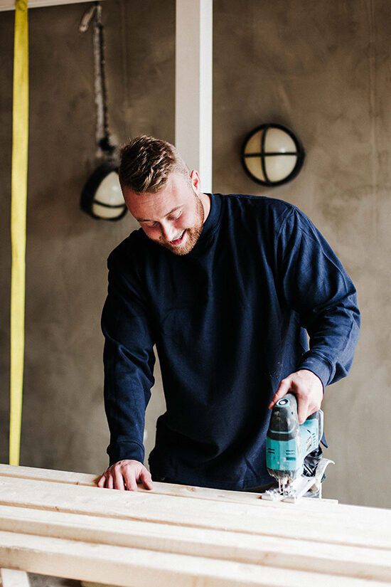 Een man werkt met hout.